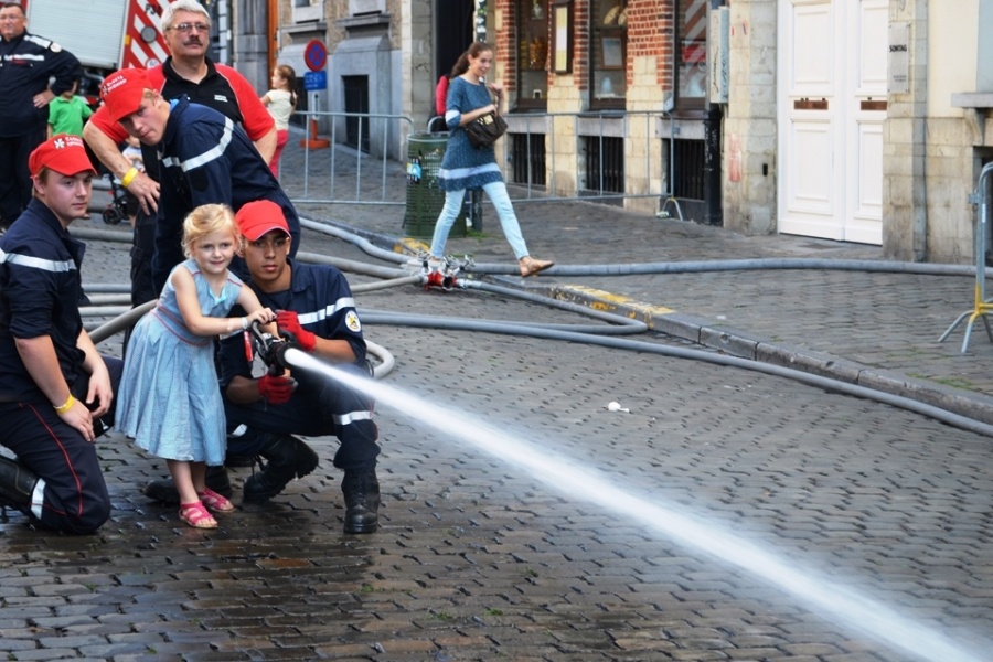 Jugendfeuerwehr lehrt Kinder, einen Feuerwehrschlauch festzuhalten